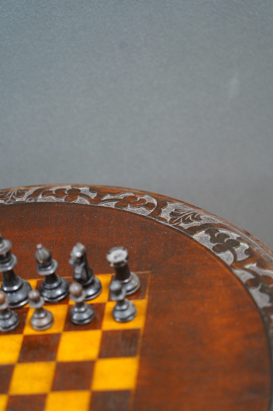 A Victorian carved walnut games table and chess pieces, table 74cm tall, king 6cm tall. Condition - good